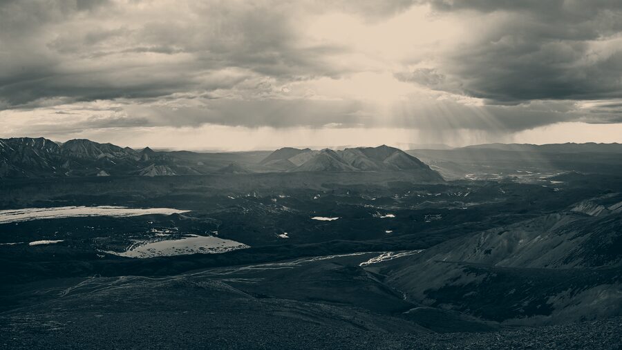 Remote mountain valley in Denali backcountry under heavy cloud, no roads or buildings in sight.