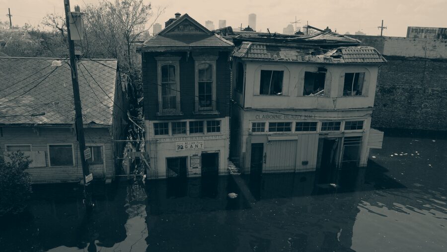 A flooded street of damaged buildings in the days after a hurricane.